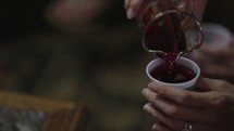 pouring wine into small cups for communion 