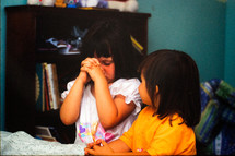 Little sisters praying at bedside