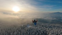 Dream flying paragliding above foggy clouds in winter forest nature, freedom adrenaline adventure
