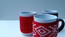 sweaters around coffee mugs 