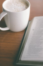 coffee cup and an open Bible