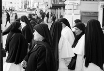 a group of nuns walking down a street 