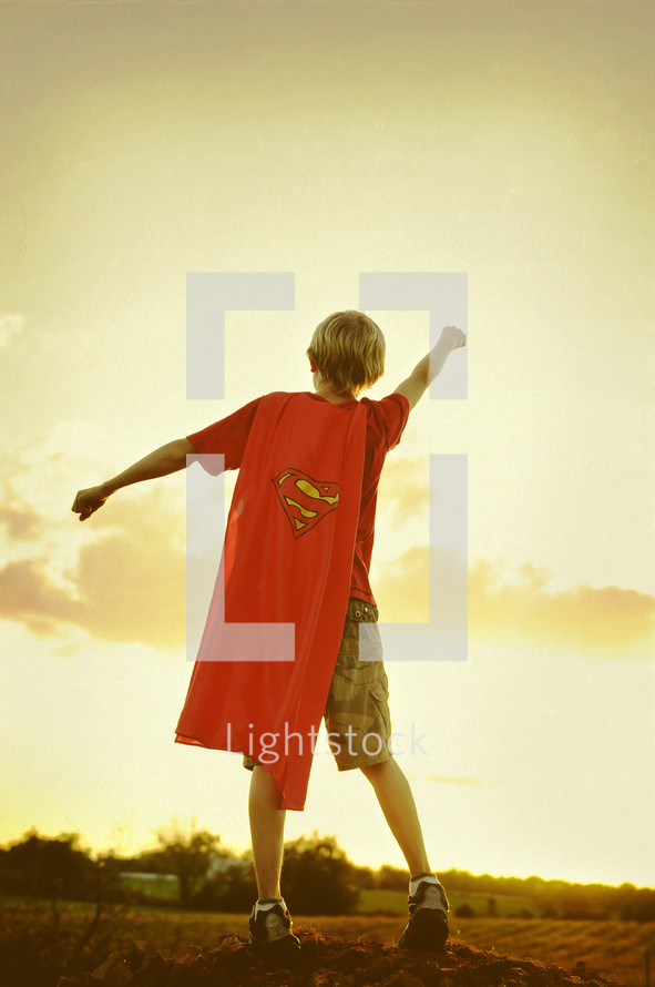 Boy with cape pretending to take off 