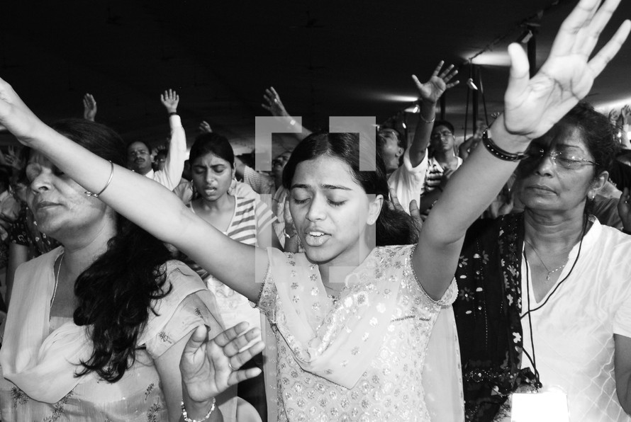 Indian woman with her hands raised in worship to God