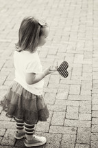 girl toddler holding a heart shape on a stick 