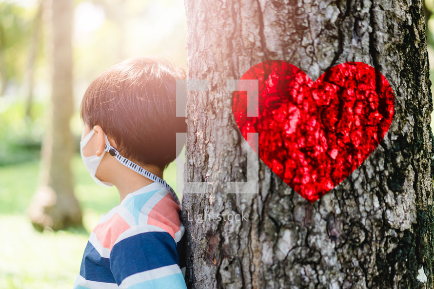 a child wearing a face mask and red heart of a tree trunk 