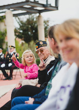 A Veteran holding his granddaughter in his lap 