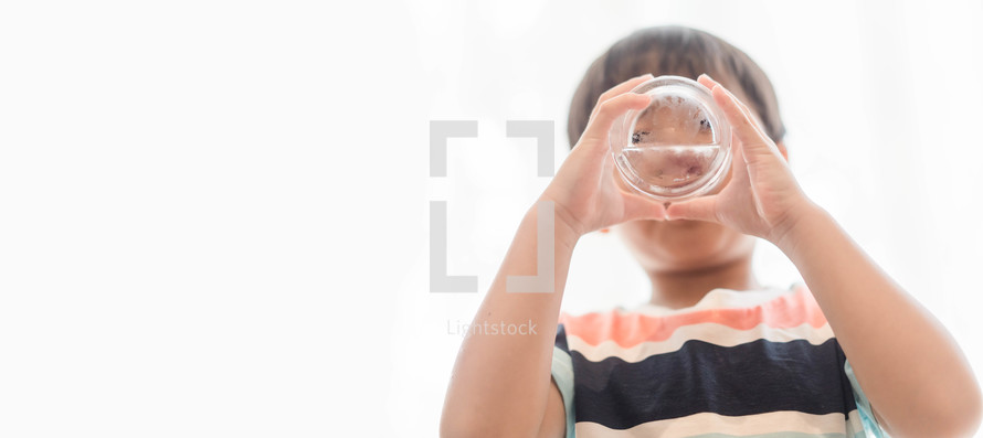 a child drinking a glass of water 