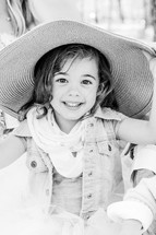 a little girl in a bonnet playing dress up