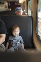 toddler boy in a train seat 