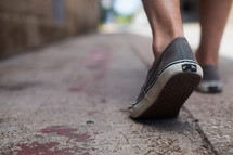 shoes walking on a sidewalk 