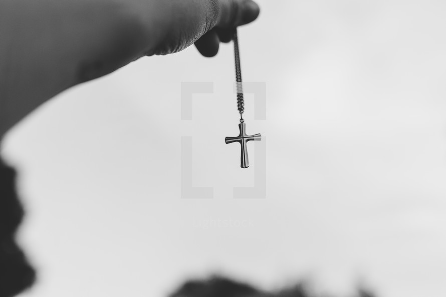 man holding a cross necklace 