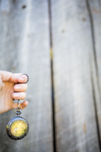 hand holding a pocket watch on a chain 