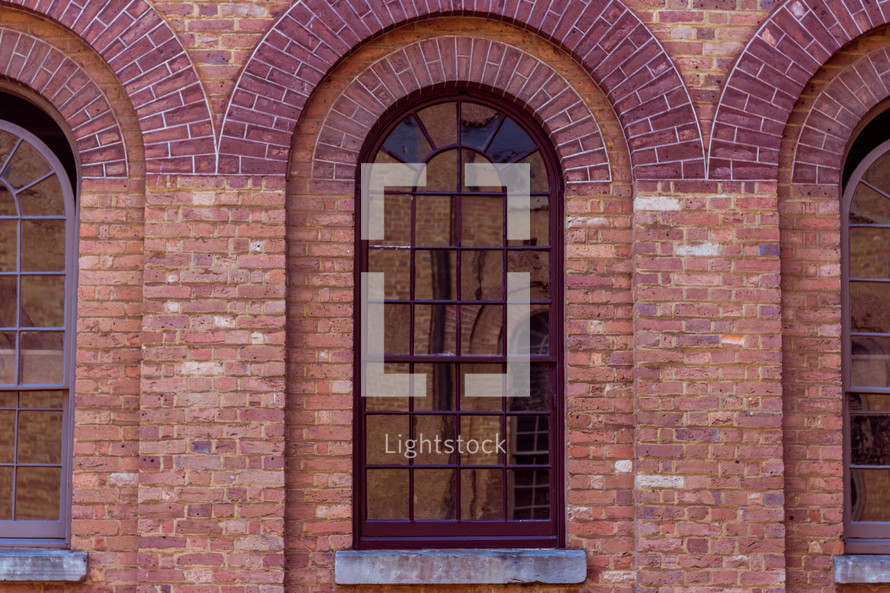 reflection in the glass of a window on a brick building 