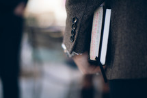 man carrying a Bible and journal at his side heading to a Bible study