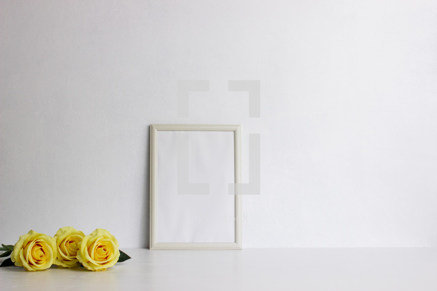 yellow roses and blank frame 
