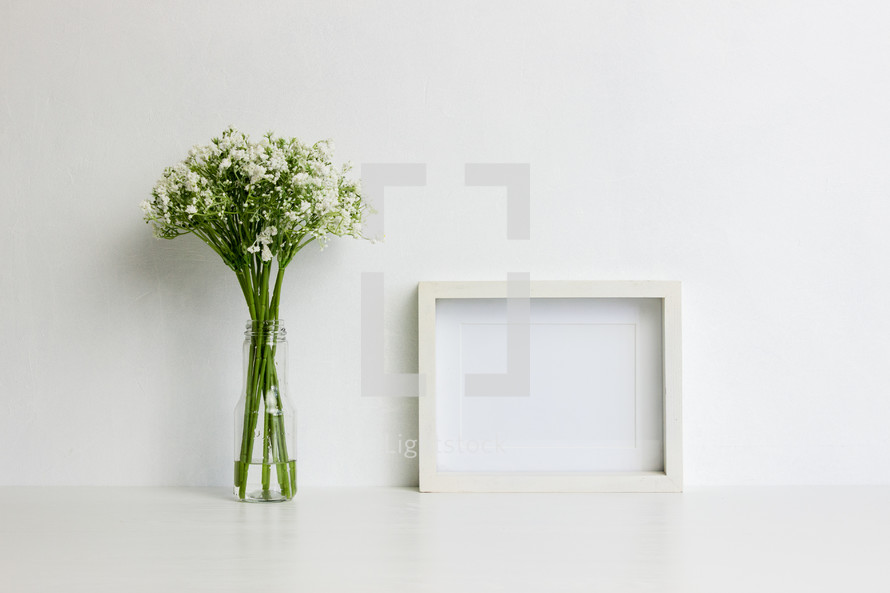 vase of flowers and blank frame 