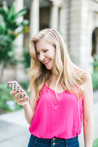 smiling woman looking at her cellphone screen 