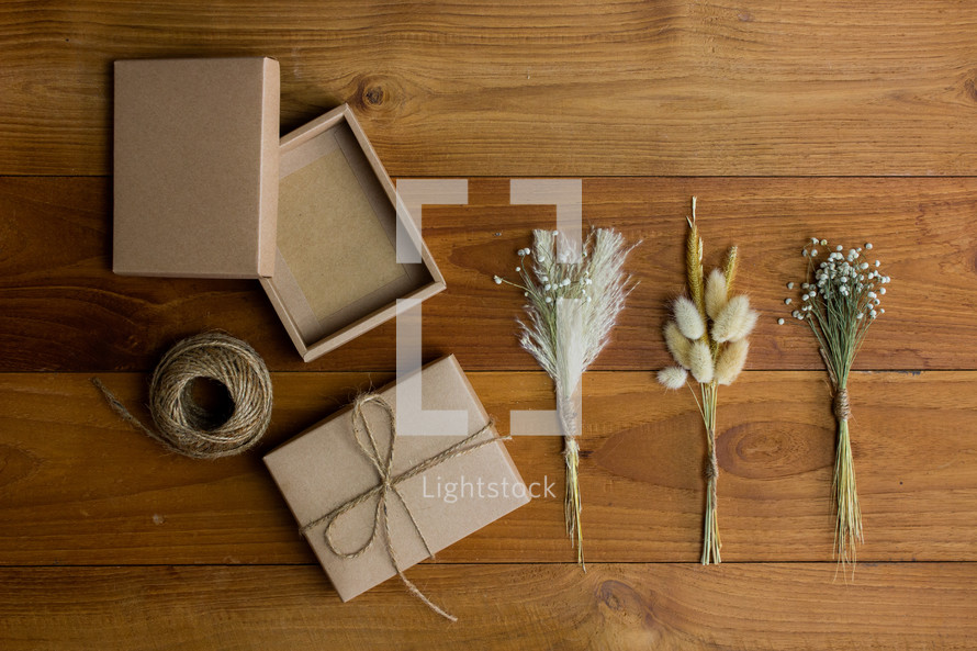 wrapped brown paper gift box and wheat and flower stalks 
