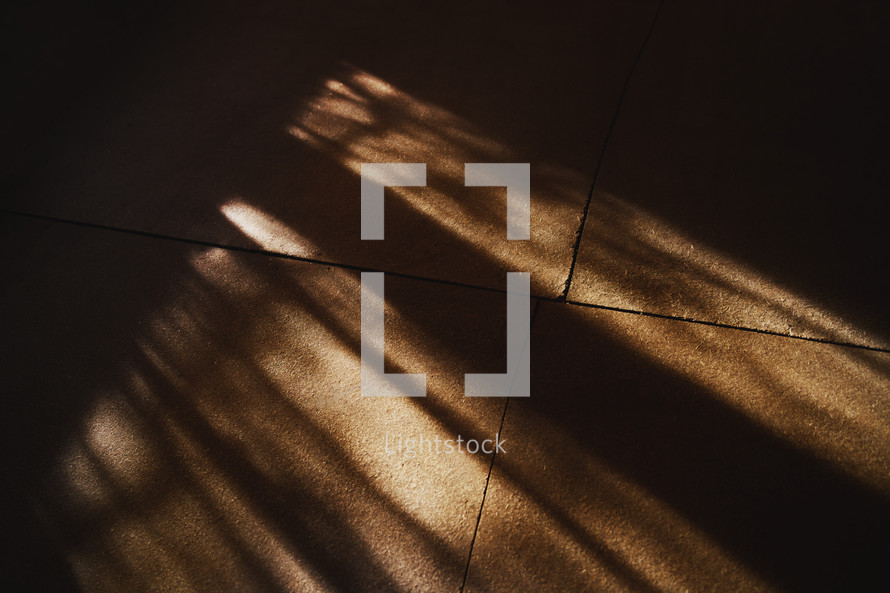 Sunbeam shadows on a vintage rural wooden floor of a dark room