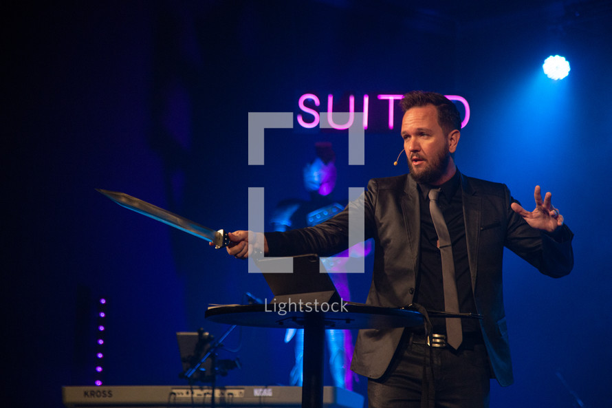 a pastor holding a sword during a worship service 