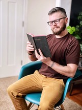a man sitting reading the Bible 