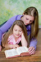 mother reading the Bible to her daughter