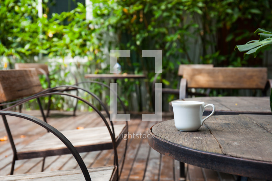 coffee mug on a wooden table outdoors 