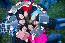 youth group lying in the grass reading Bibles 