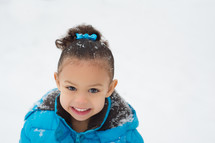 smiling toddler girl playing in the snow