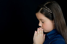 A young girl with praying hands 