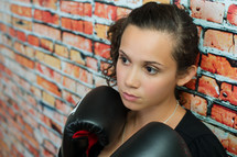 female boxer against a brick wall