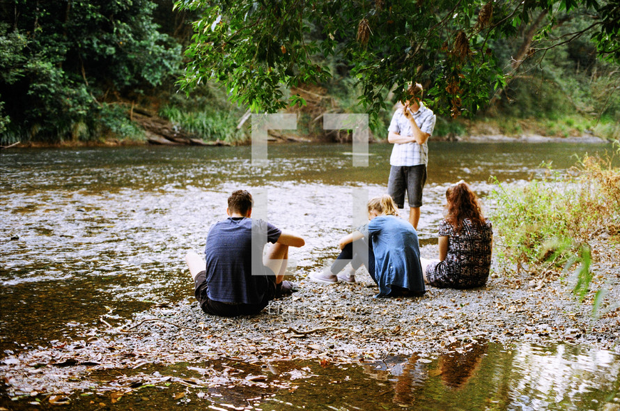 A group of youth sitting by a river