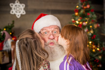 toddler girls kissing Santa Claus 