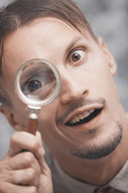 a man looking through a magnifying glass 