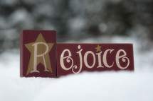 Rejoice wooden block in the snow.