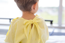 a boy child in a hospital gown walking through a hospital 