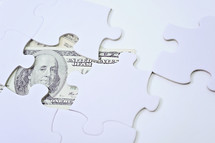 cash under a puzzle piece 
