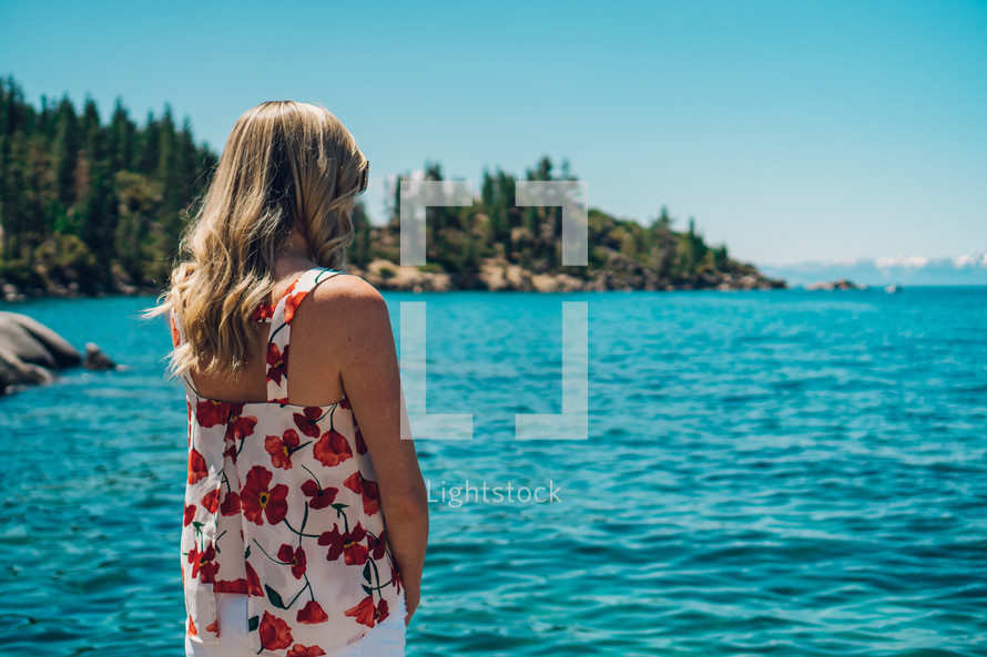 woman standing on a rock looking out at Lake Tahoe 