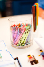 crayons in a cup on a table 