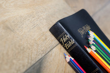 row of colored pencils on a Bible