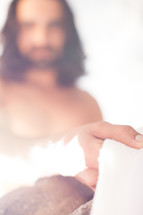 glowing Jesus holding a white shroud