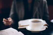 steam from a coffee mug and a man reading a Bible