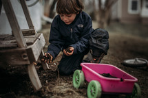 boy playing in dirt in the backyard 