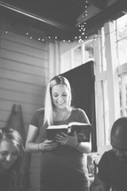 Woman reading to a group at a Bible study 