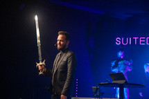 a pastor holding a sword during a worship service 