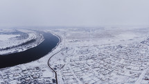 aerial view over a city in winter covered in snow 