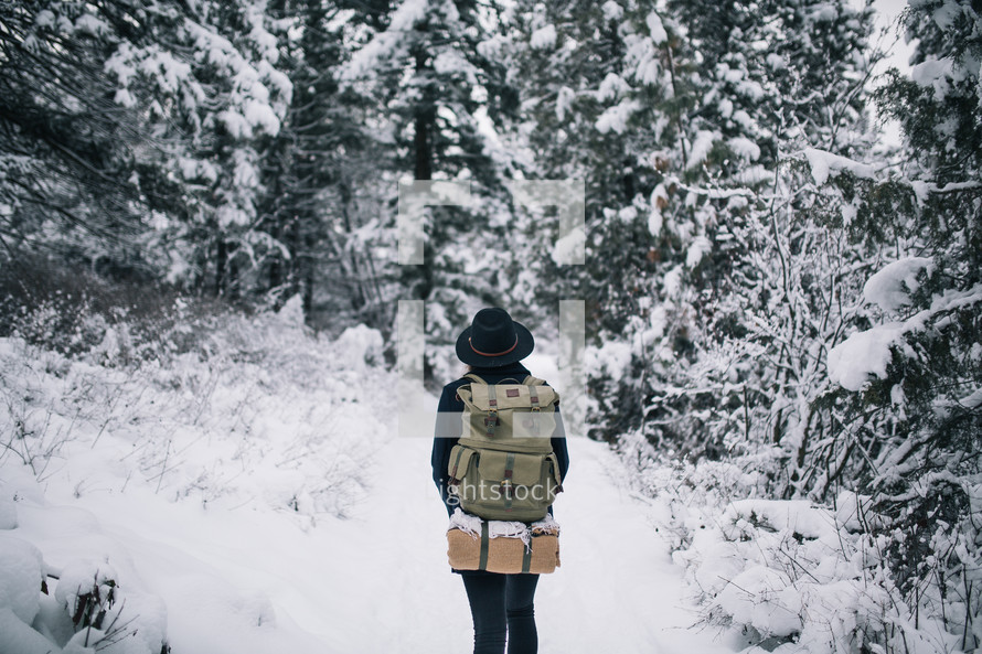 a woman backpacking through the snow 