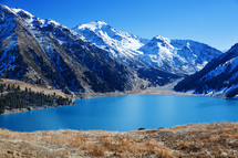 lake surrounded by snow capped mountains 
