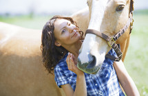 Woman and horse together at paddock